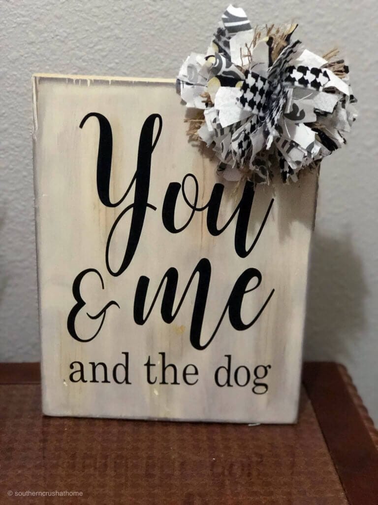 messy bow on top of a sign that says "you and me and the dog"
