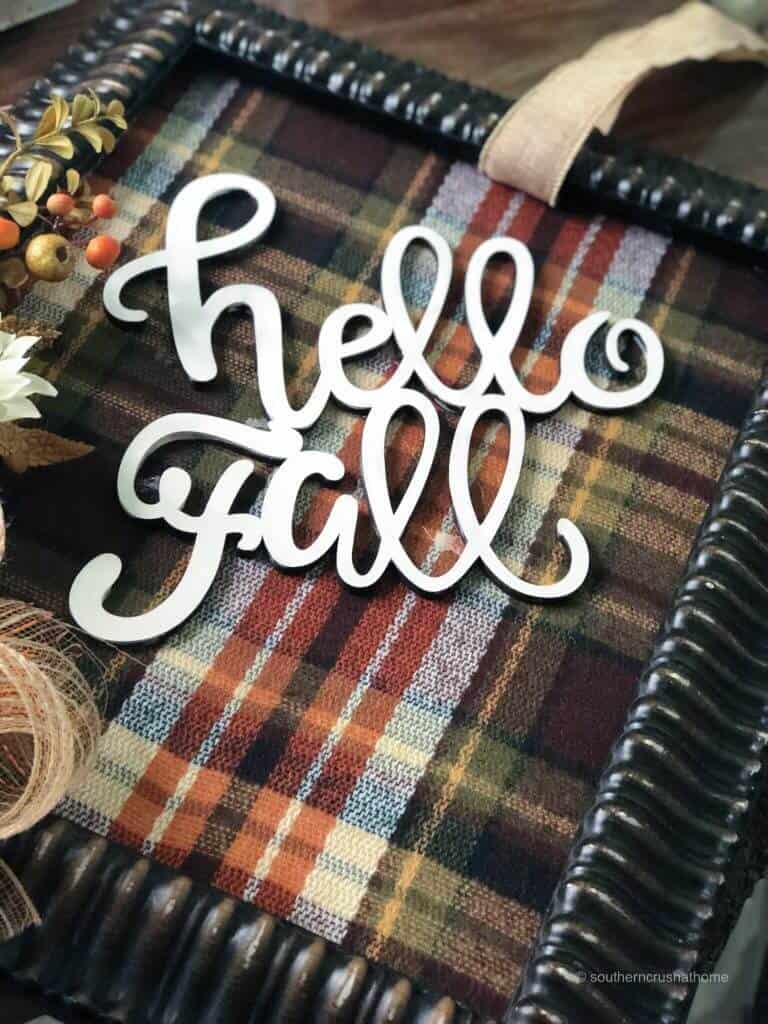 Hot gluing hello fall cutout to plaid fabric