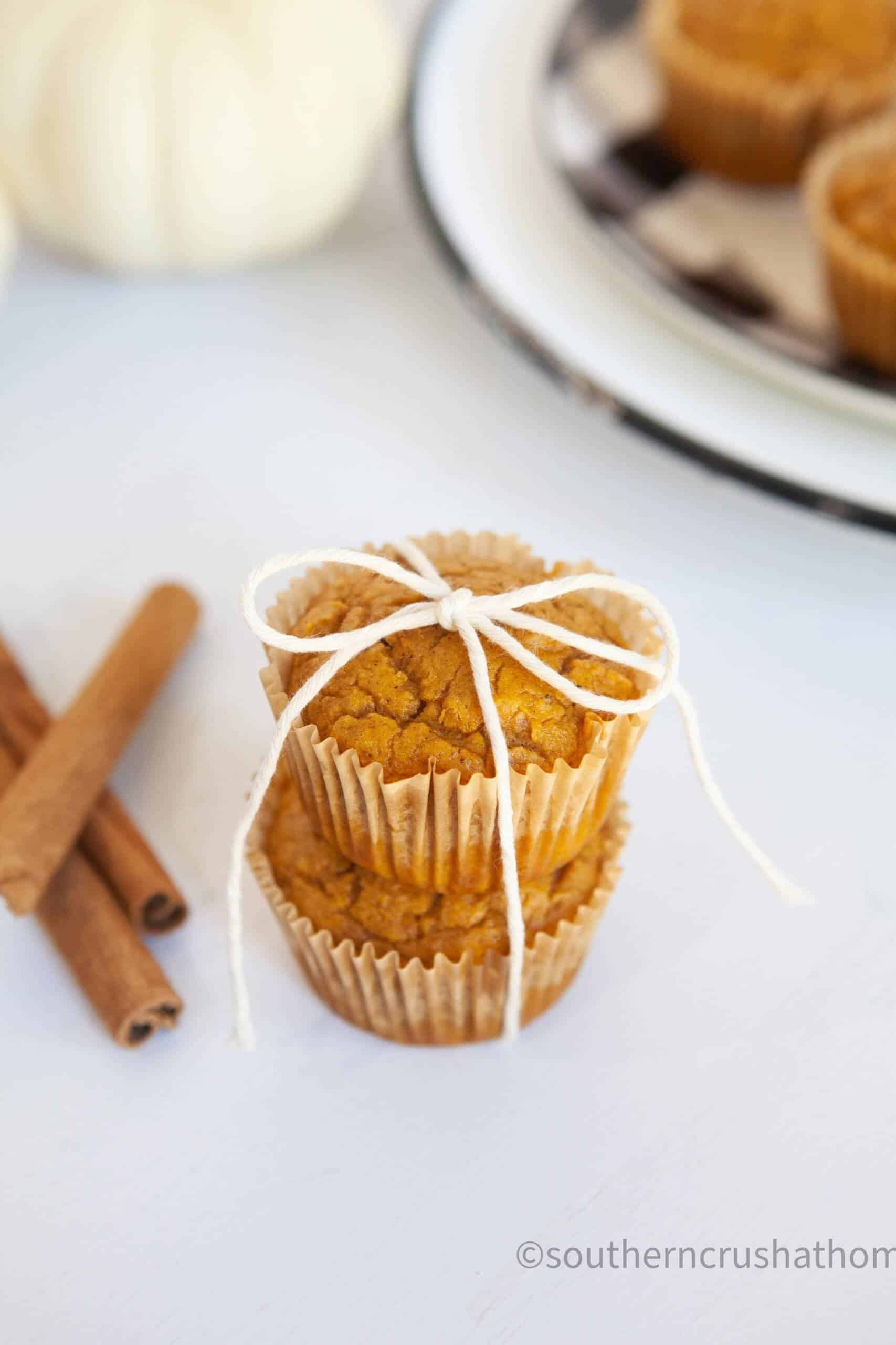 3 ingredient pumpkin muffins stacked with cinnamon sticks