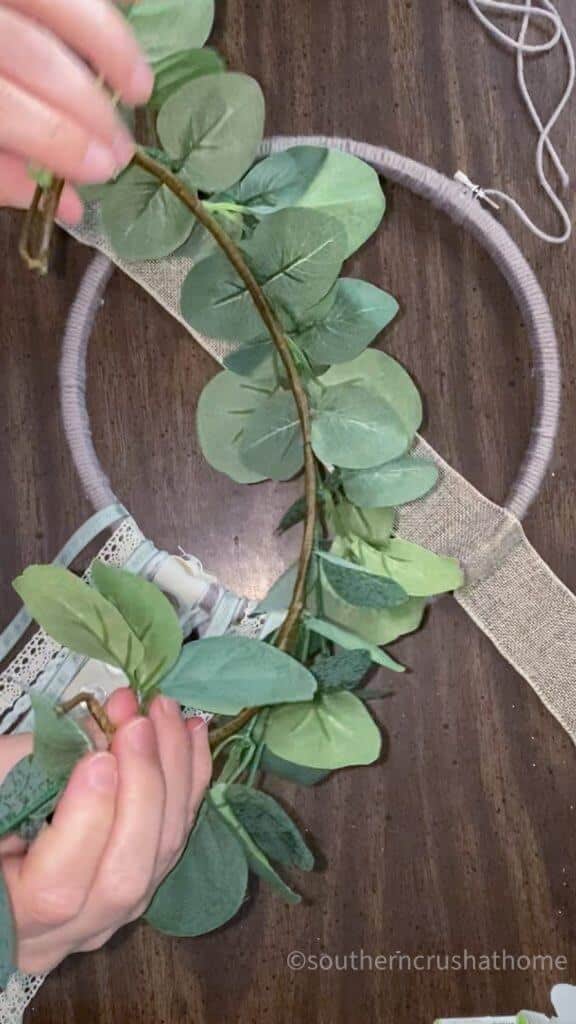 attaching greenery to embroidery hoop