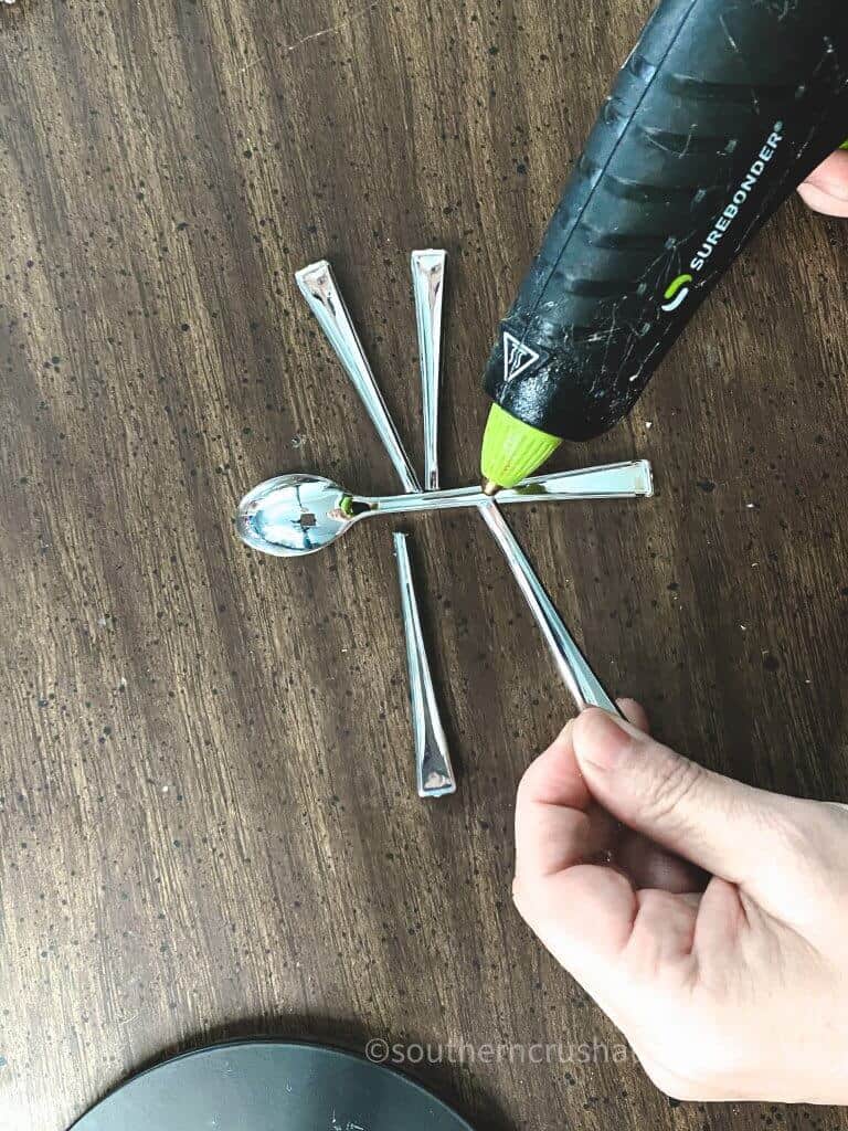 hot gluing plastic spoons to center of dragonfly