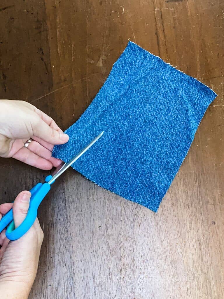 cutting slits into jean square for messy bow