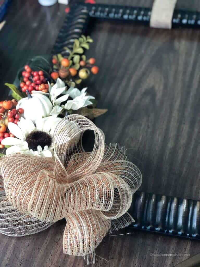 mesh ribbon attached to fall frame with fall flowers