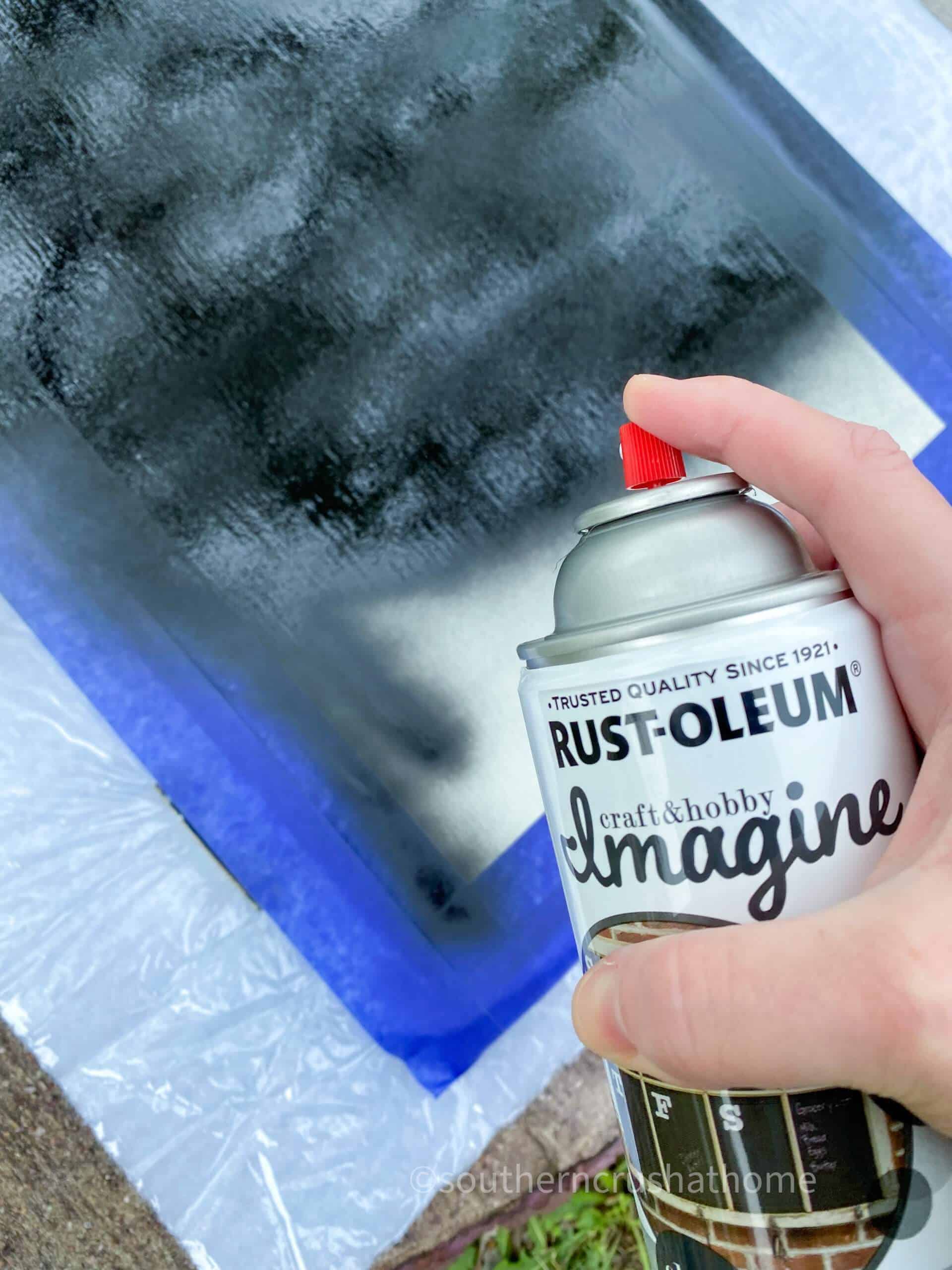 spraying chalkboard paint on cabinet door