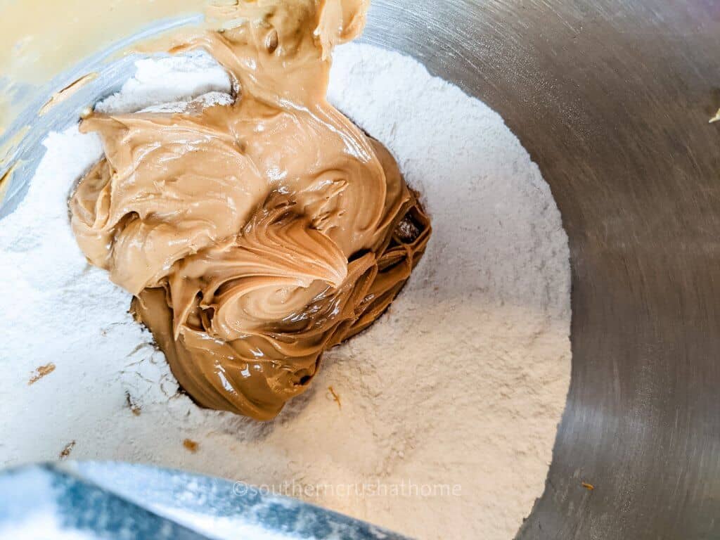 adding peanut butter to mixing bowl