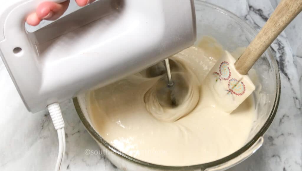 using mixer to mix ingredients for poke cake
