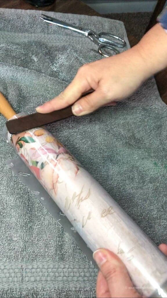 rubbing a floral transfer onto a decorative rolling pin project