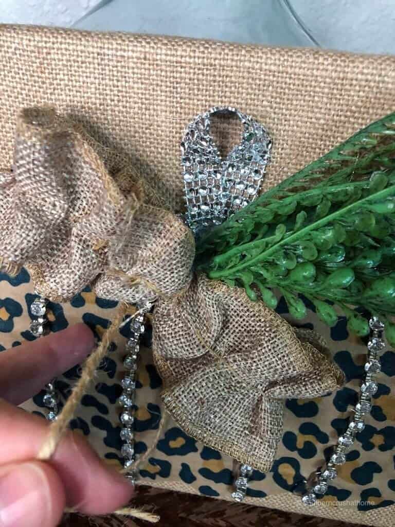 Attaching a burlap bow to the leopard pumpkin