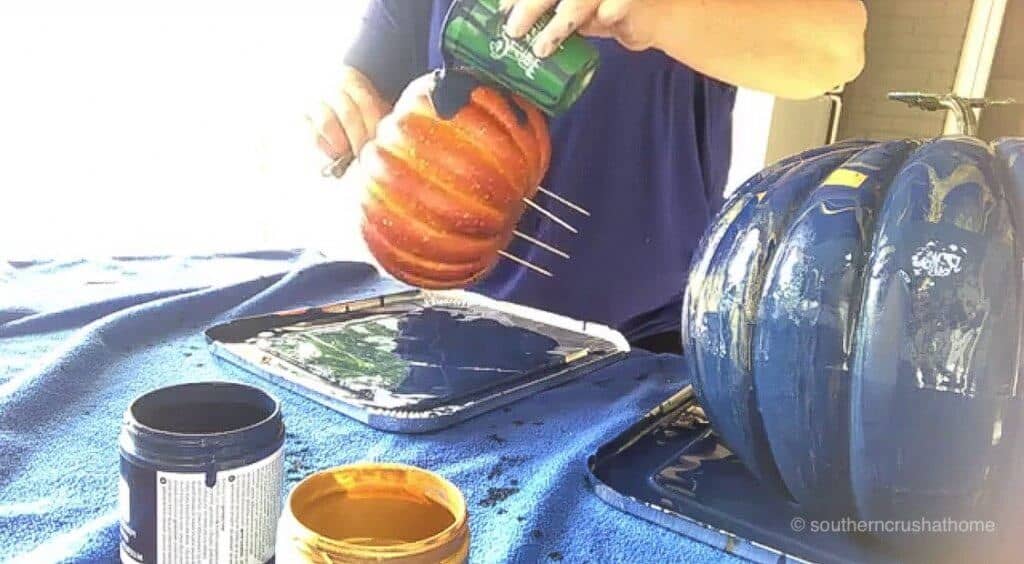 Pouring paint on a plastic pumpkin 