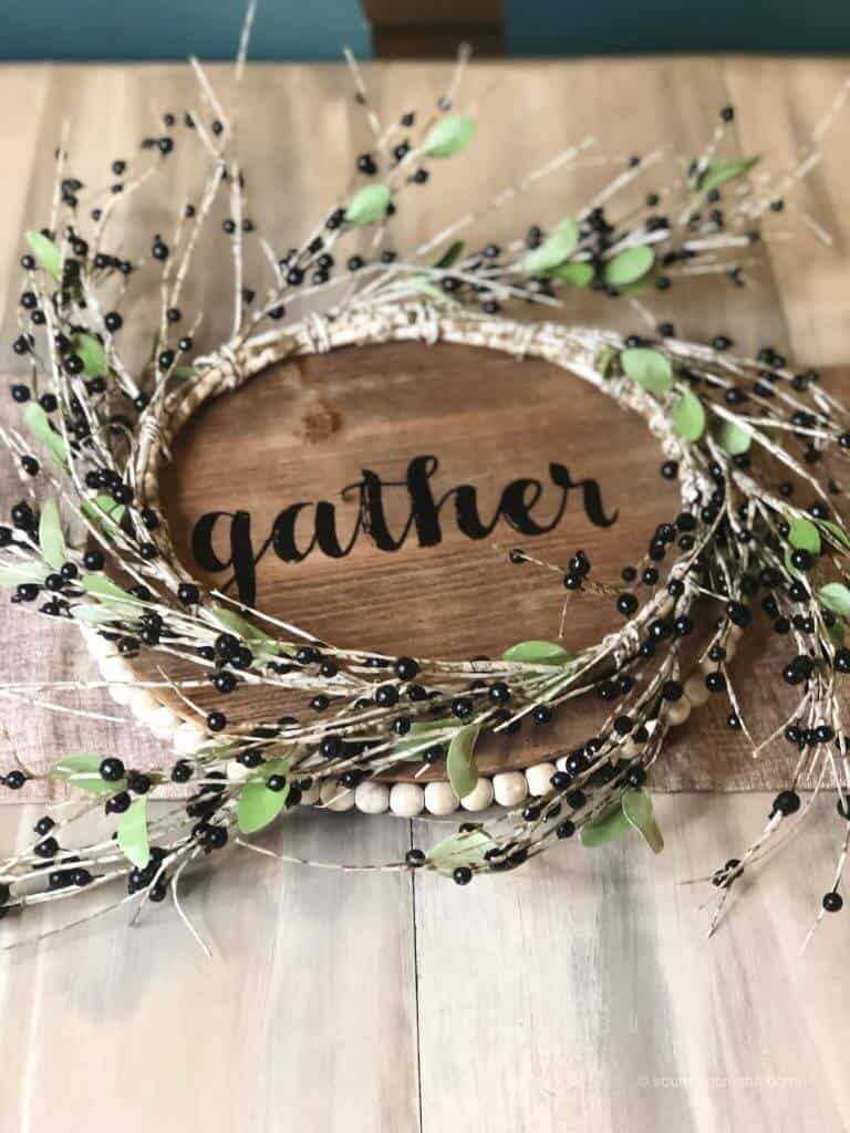 A wreath of greenery on a round wooden sign