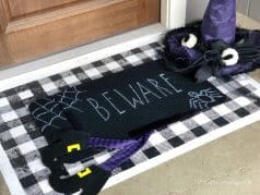 halloween doormat layered on top of a diy buffalo check doormat