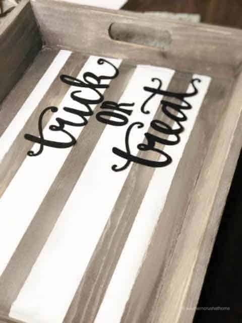 The words "trick or treat" on a wooden tray