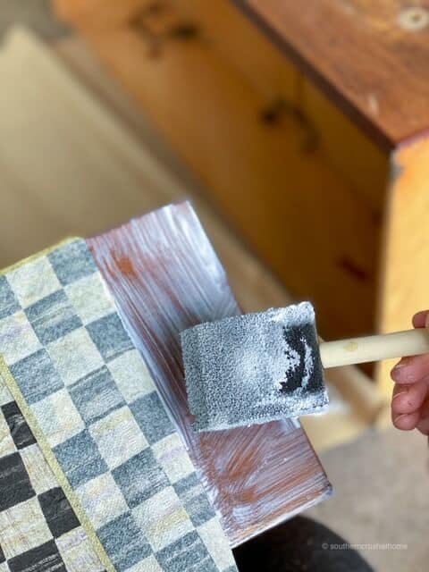 Using a foam brush to apply Mod Podge to a dresser drawer