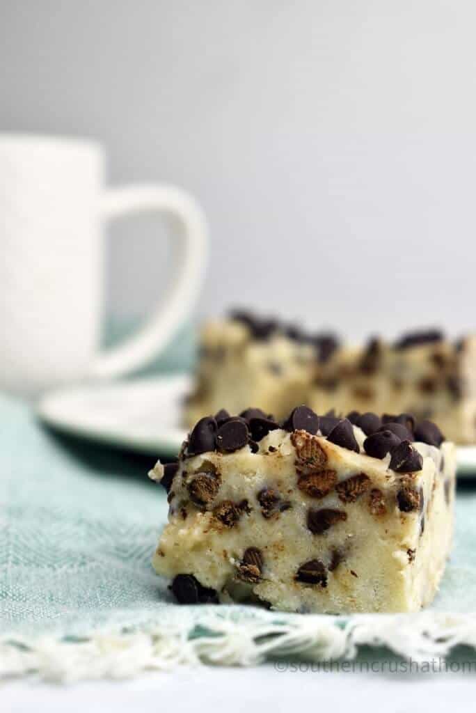 Cookie dough fudge with a white mug in the background.