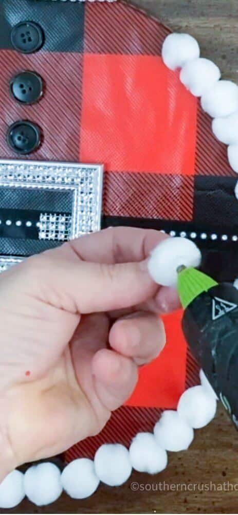 gluing pom pom onto splatter screen ornament