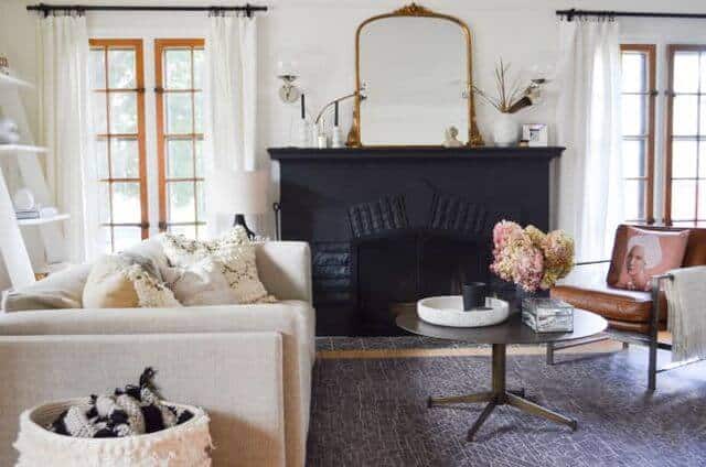 living room with black fireplace and gold mirror