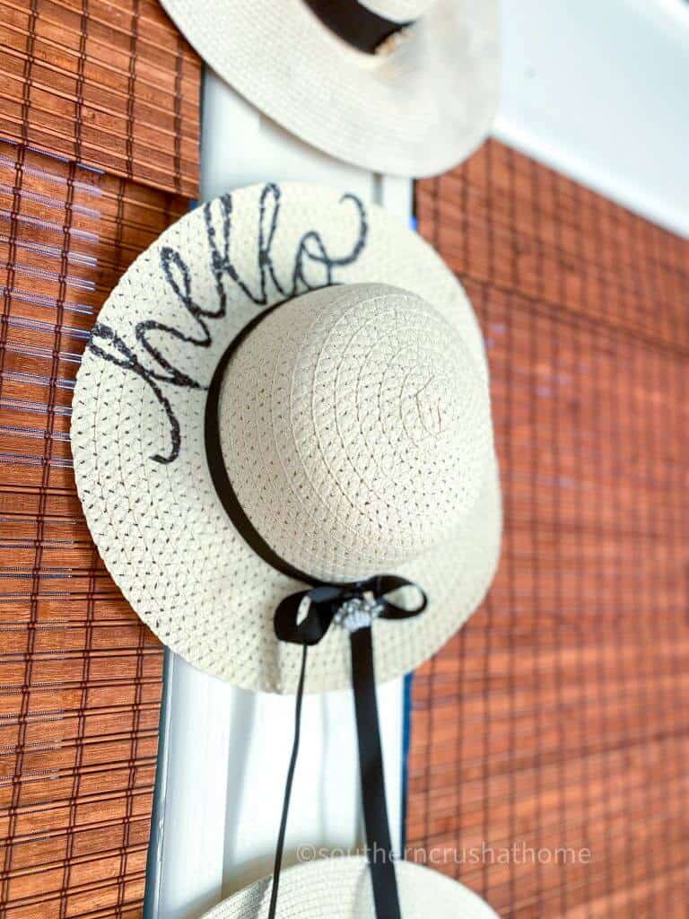 trio of sun hats hanging on porch wall