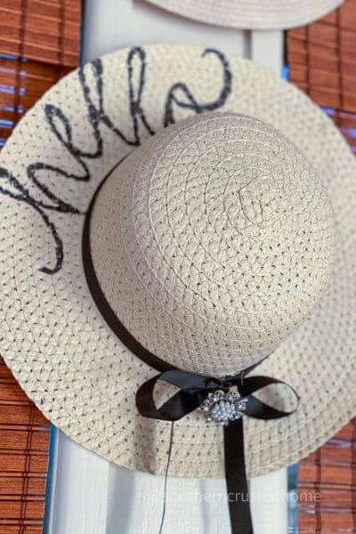 floppy straw sun hat hanging on wall