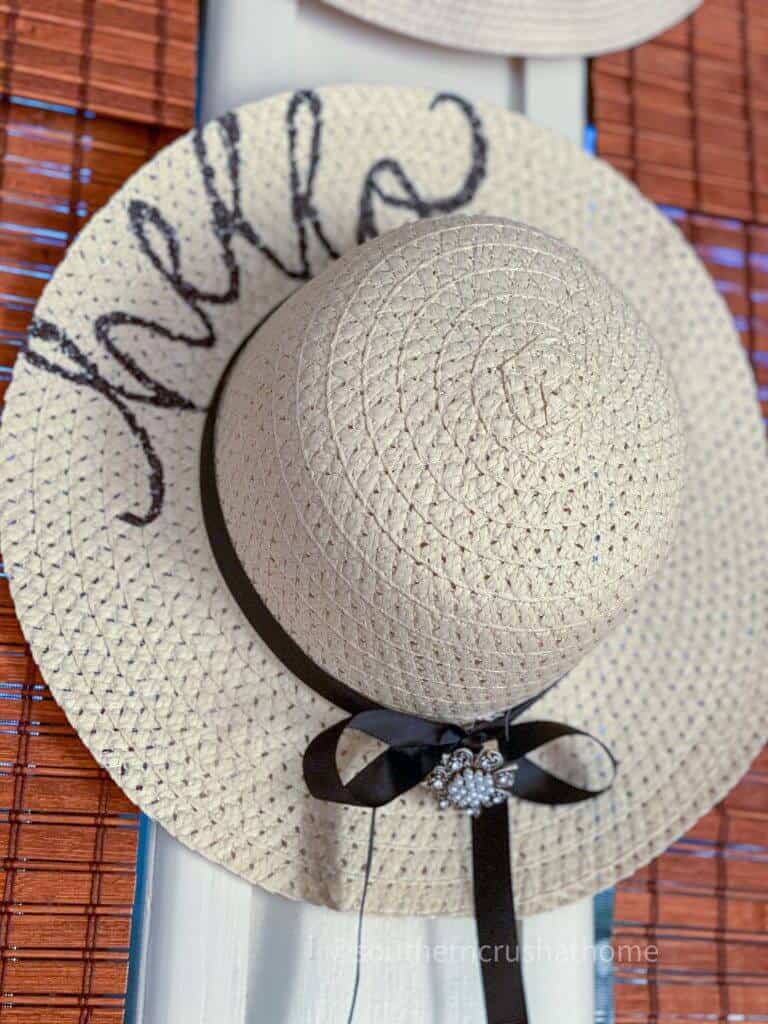 floppy straw sun hat hanging on wall