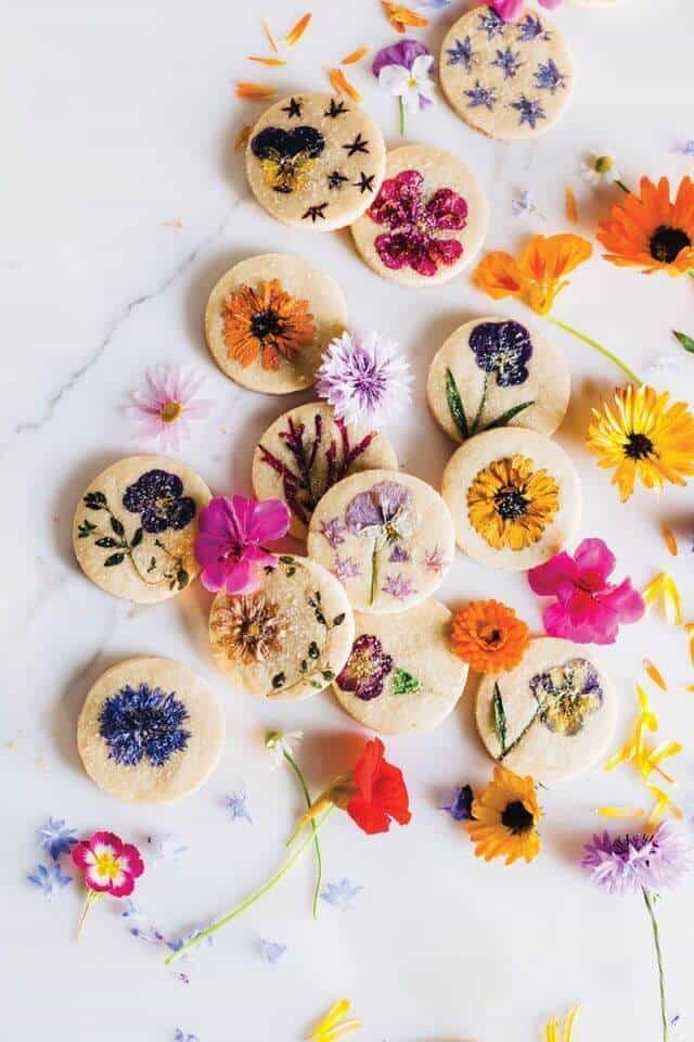 cookies with edible flowers on marble counter