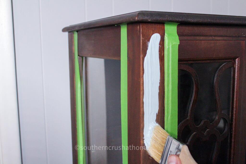 vintage cabinet with masking tape and paint brush