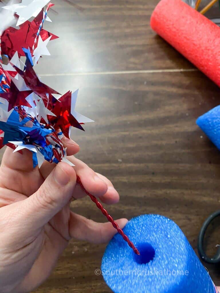 placing Fourth of July picks into pool noodle