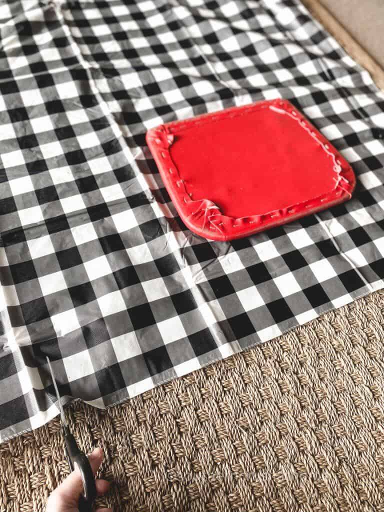 placing buffalo plaid fabric on vintage step stool