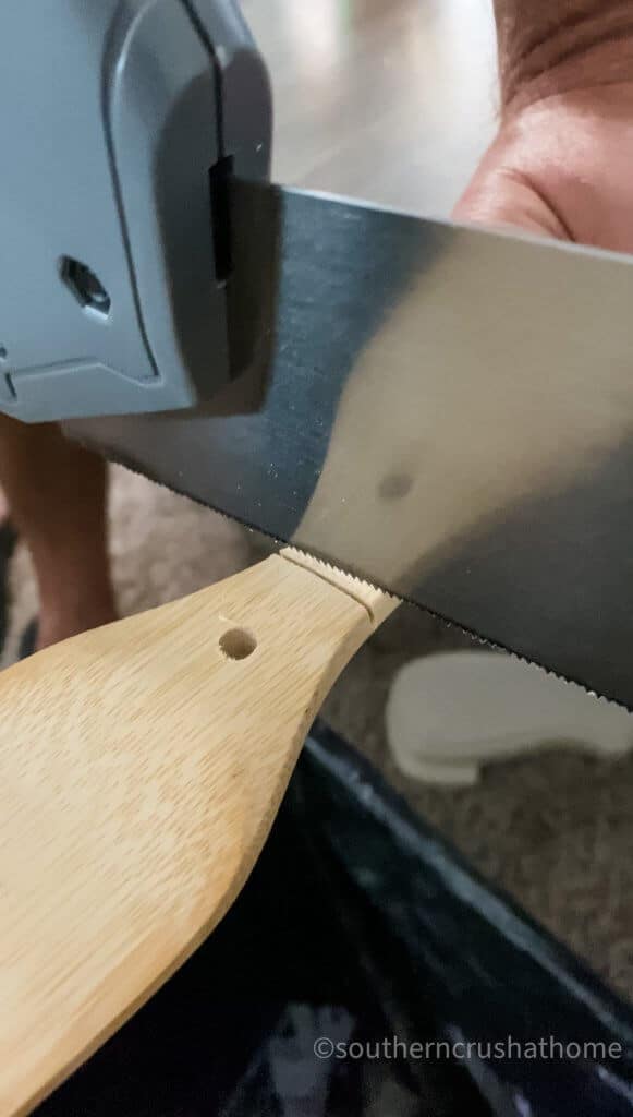 hand saw cutting wooden spatula