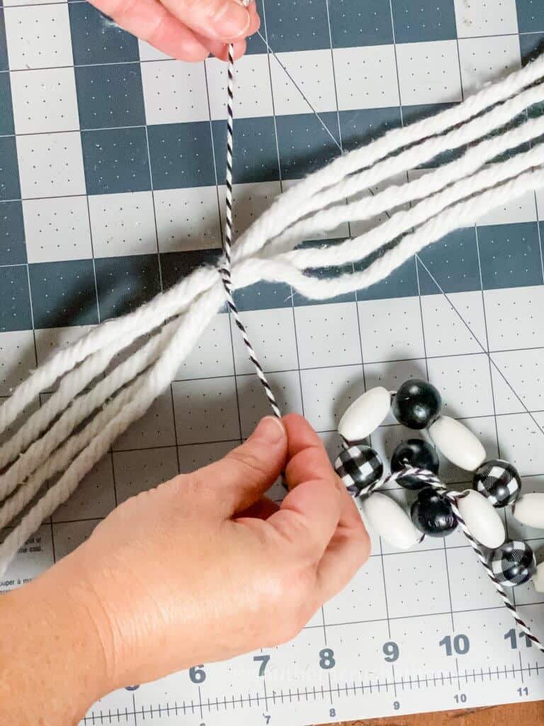 tying black and white bakers twine around mop head strands