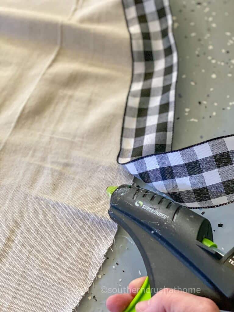 using glue gun to add buffalo check to tree skirt