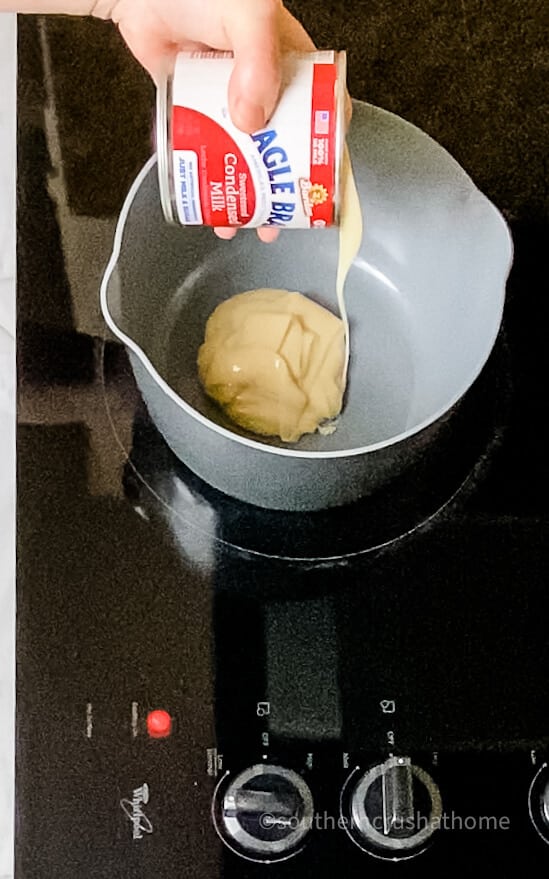 pouring condensed milk into pan on stove top