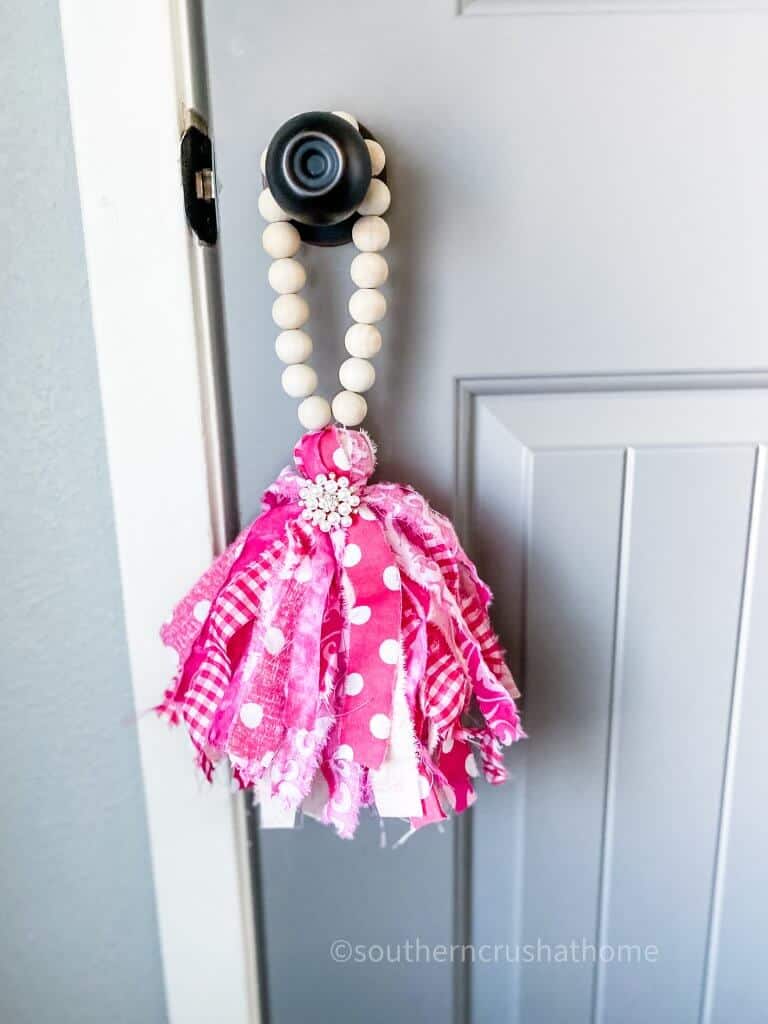 front view of wood bead garland hanging on door knob