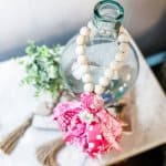 overhead view of wood bead garland hanging on glass bottle