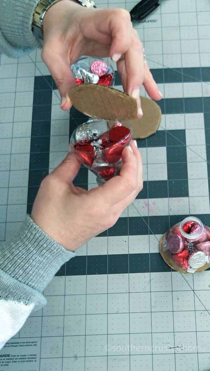 adding hershey kisses to plastic cup