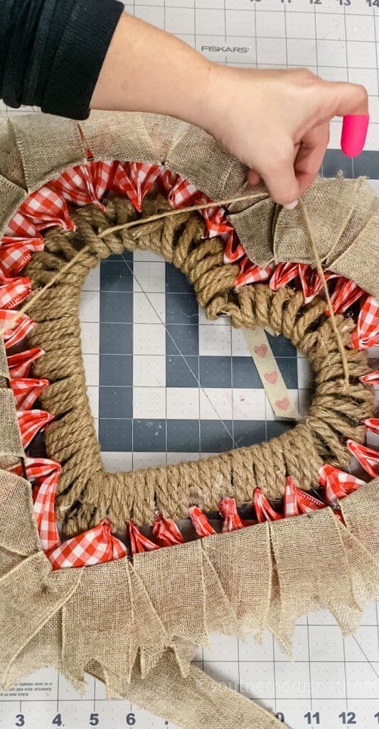 adding twine to heart wreath for hanging