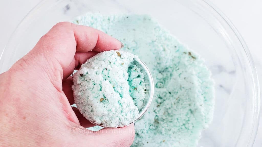 placing bath bomb mixture in mold