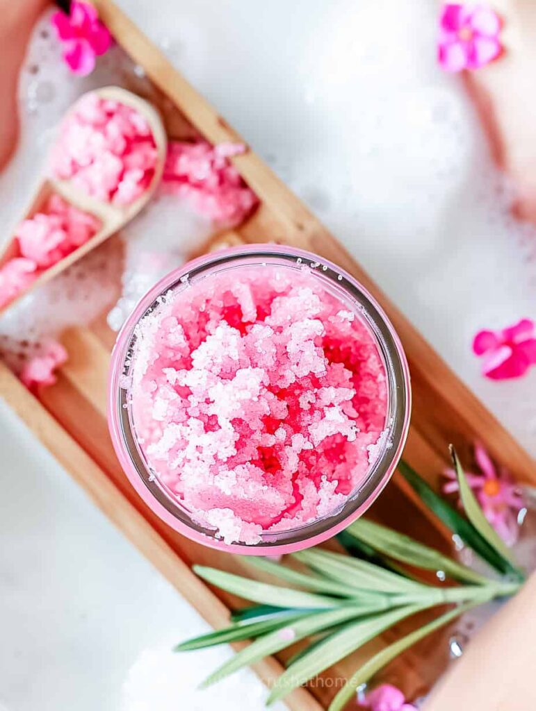 pink sugar scrub on a wooden bath tray