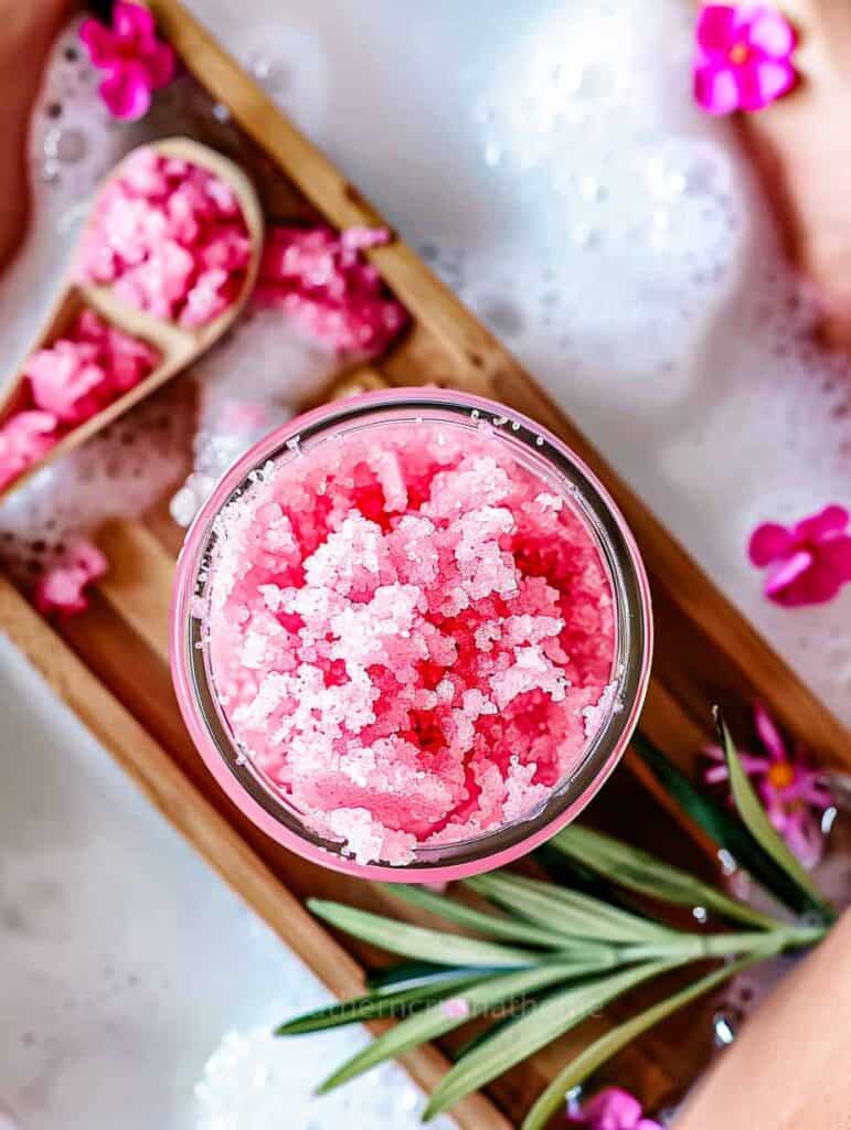 pink sugar scrub on a wooden bath tray