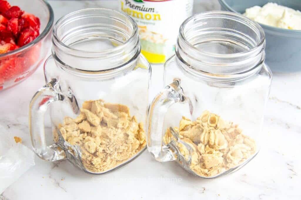 adding graham crackers to mason jars