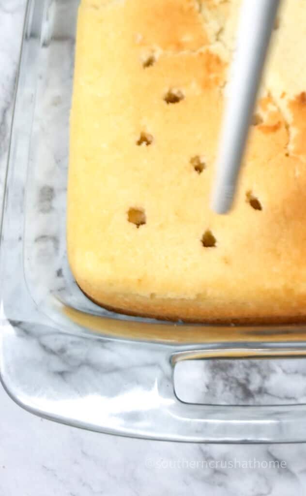 using straw to poke holes in cake