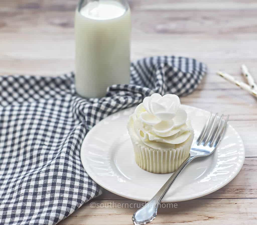single cupcake on counter with glass of milk