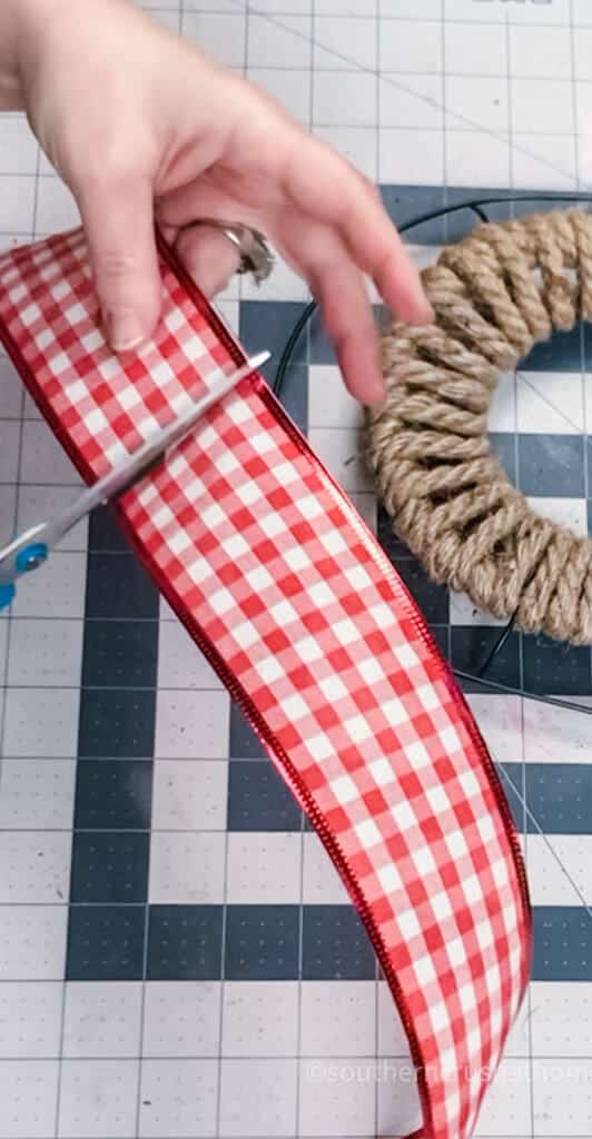 cutting red gingham ribbon for wreath