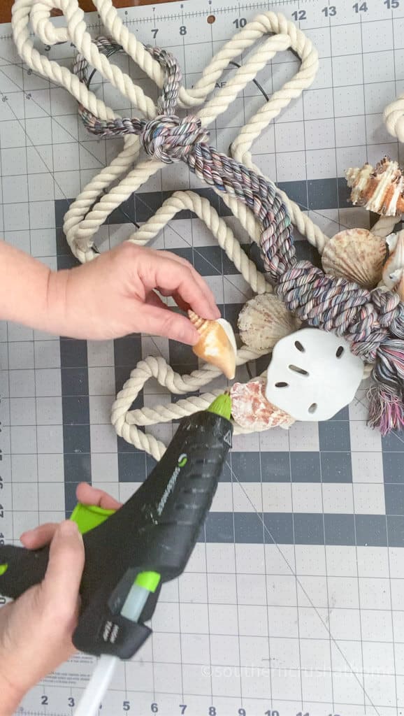 gluing seashells to coastal wreath