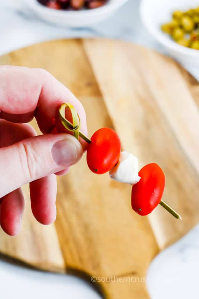 single skewer of tomatoes and mozzarella ball