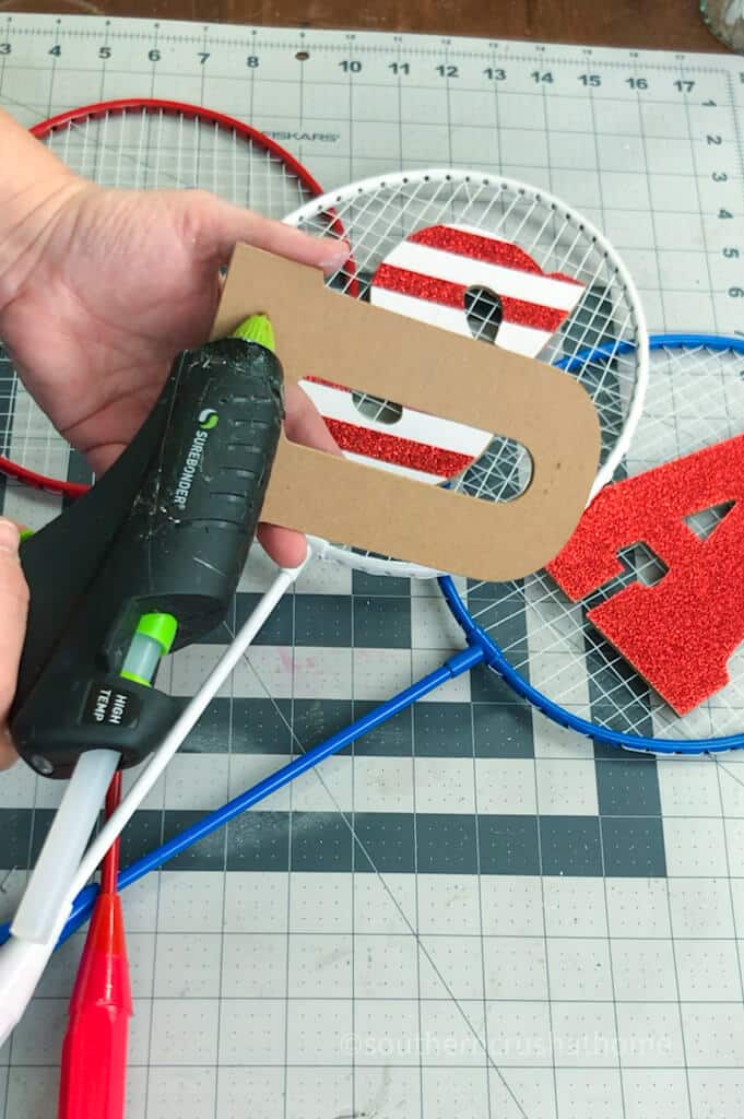 adding hot glue to wooden letters