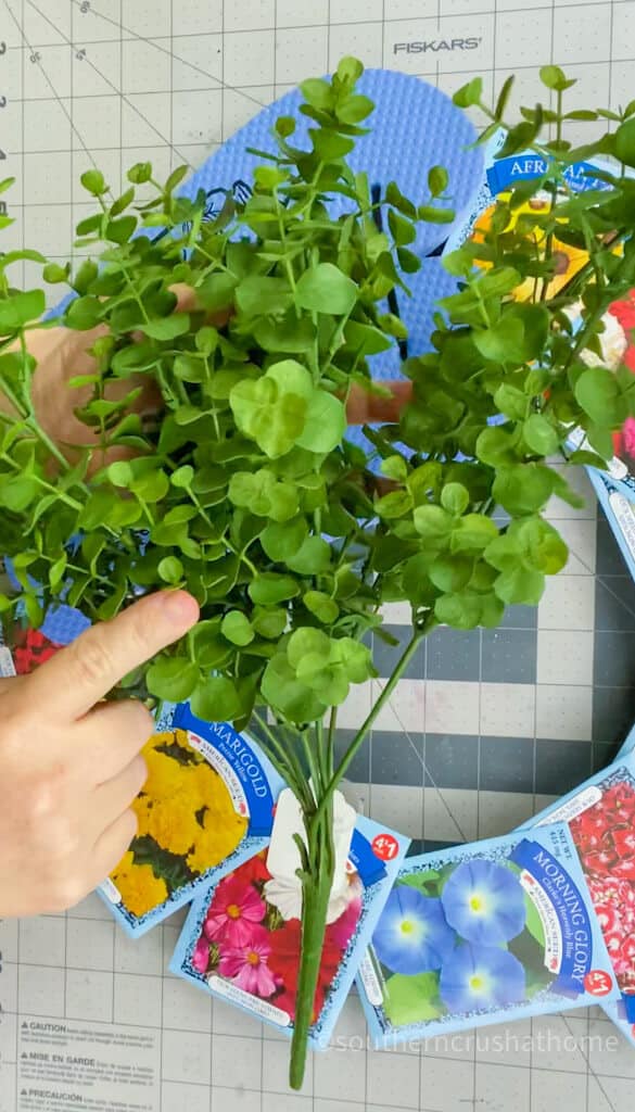 gluing greenery around wreath