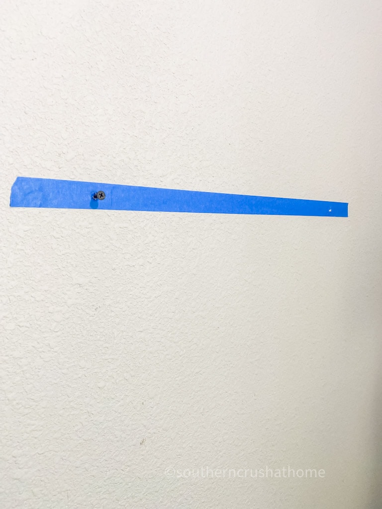 marking wall with painter's tape for screws