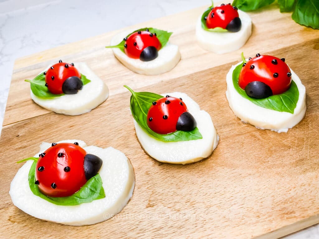 side view of caprese salad ladybugs