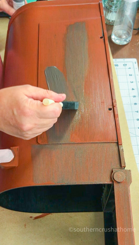 applying bronze paint to plastic mailbox