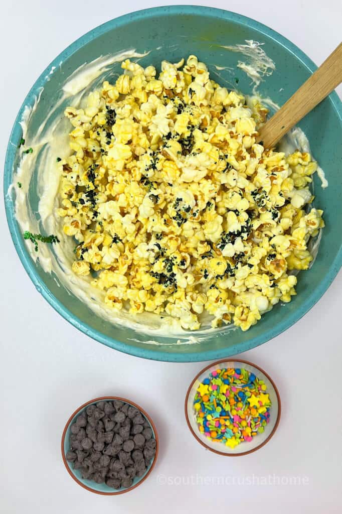 mixing popcorn with candy for popcorn balls